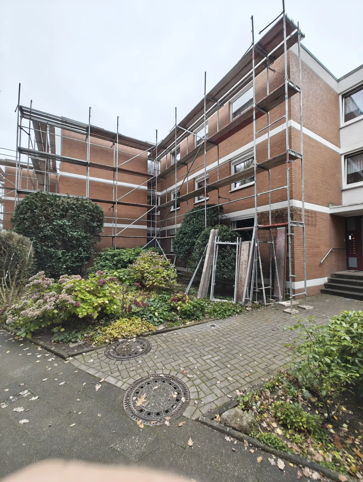 Gerüstkonstruktion in einem begrünten Innenhof